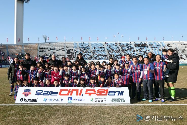 이재식 수원특례시의회 의장을 비롯한 내빈들과 어린이들이 「2026 시즌 K리그2 수원FC 홈 개막전」을 앞두고 기념촬영을 하고 있다.