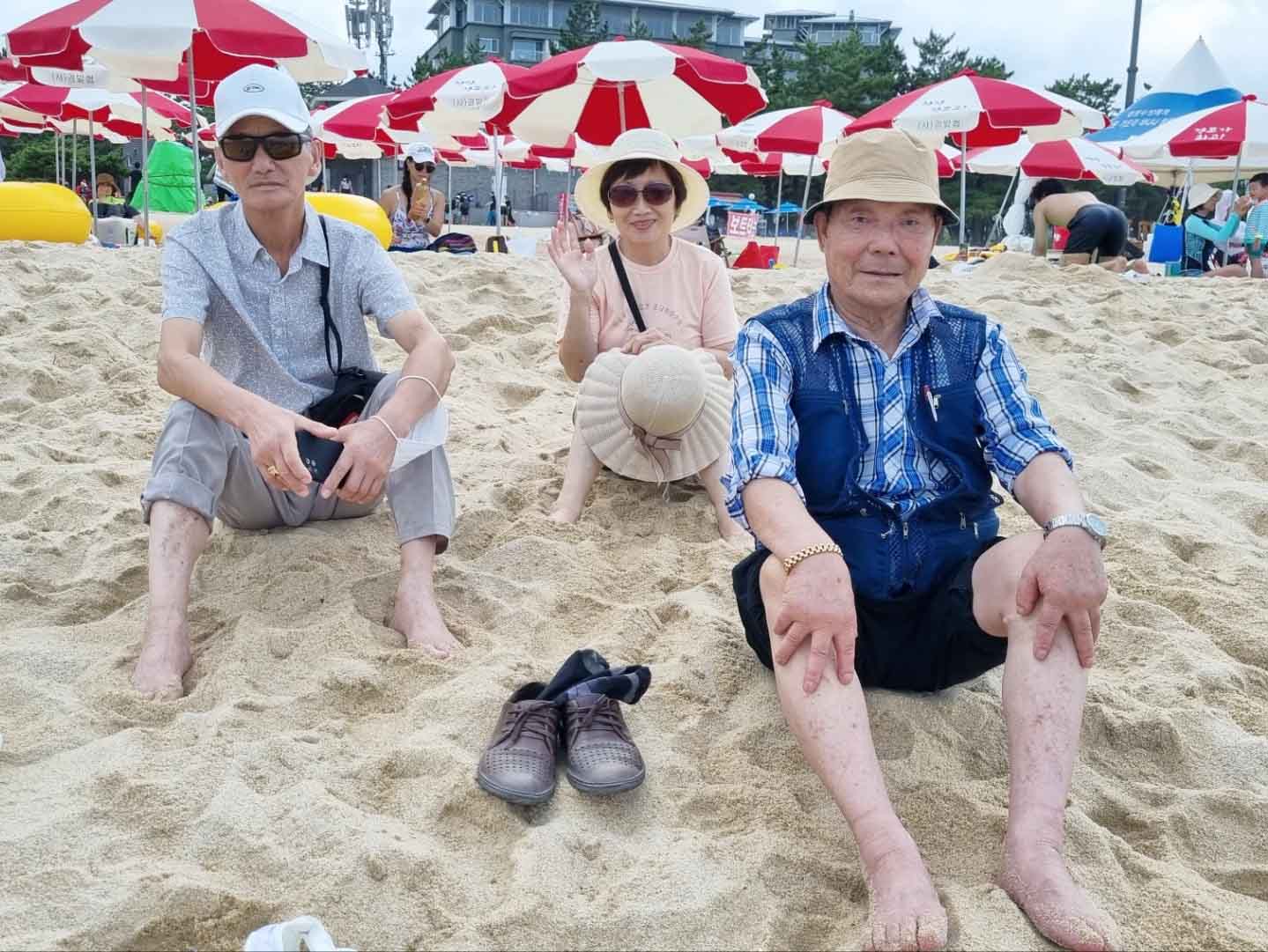 민들레실버대학, 2022 강릉수학여행의 참가자들이 주문진 모레사장에서 휴식을 취하고 있다.