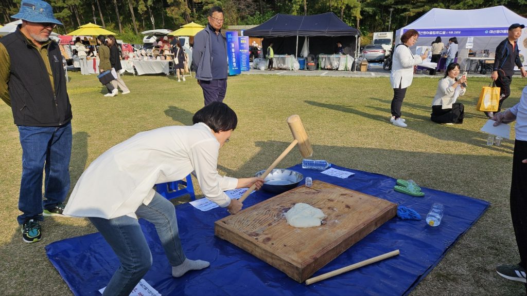 개막식에 참석한 마을활동가들이 떡메치기 체험을 하고 있다.