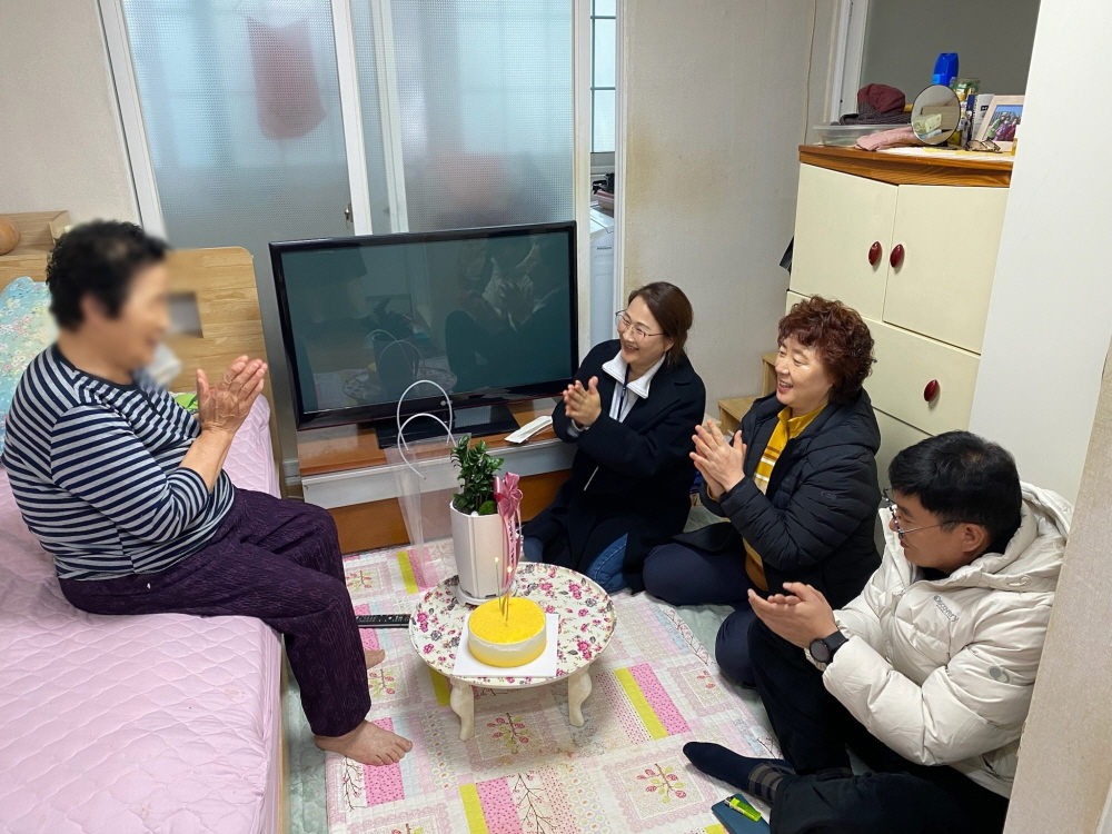 생일을 맞은 신OO씨는 꽃선물을 받으며 기뻐하고 있다.