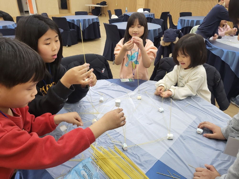 마시멜로우 게임을 통해 서로 협력하는 것을 배워가고 있다.